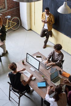 Group of young professionals collaborating in a modern office setting, brainstorming and working together