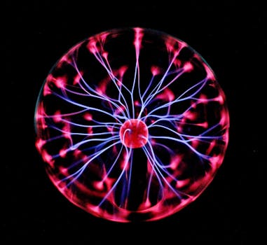 Close-up of a plasma globe with vibrant neon sparks against a dark background.